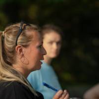 woman holding a clipboard talking